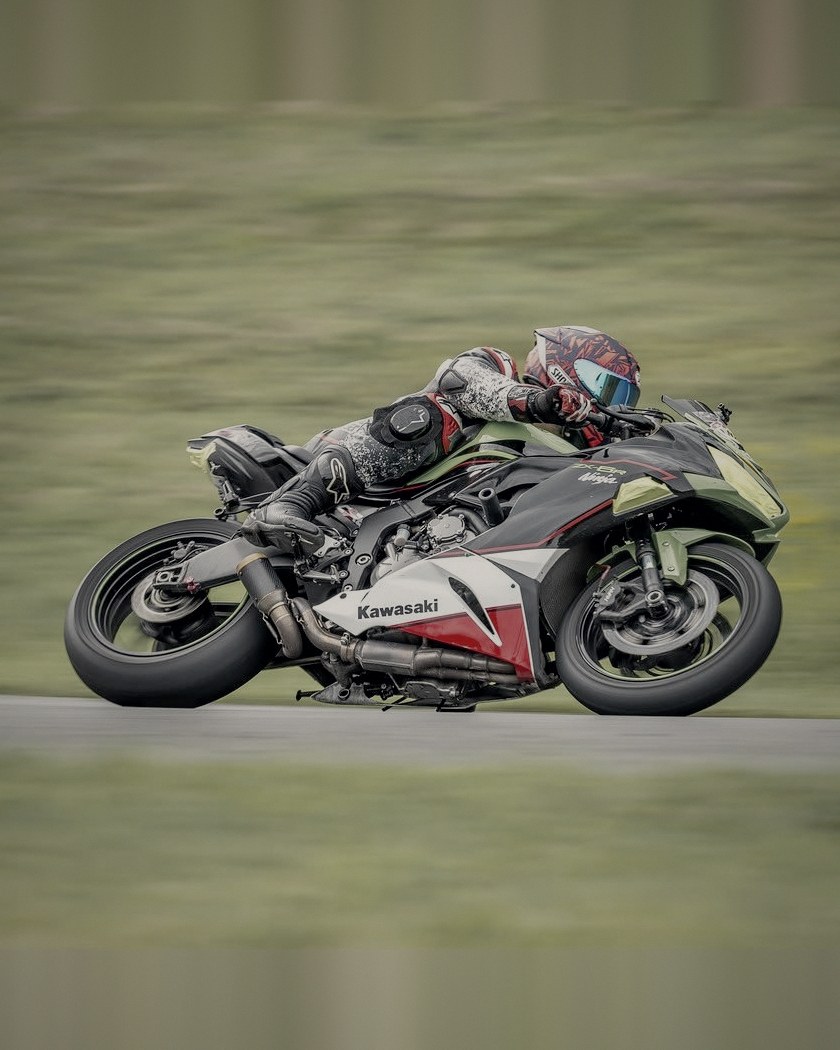Green Kawasaki ZX-6R at full lean, panned at speed