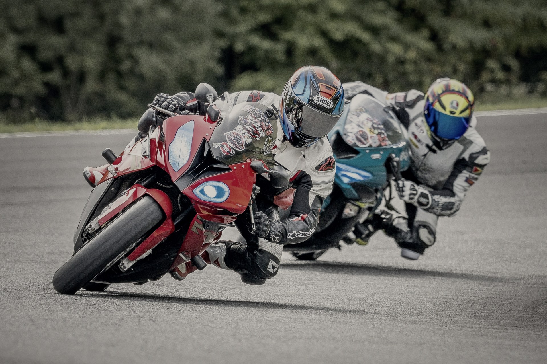Three riders side by side through a corner at NY Raceport